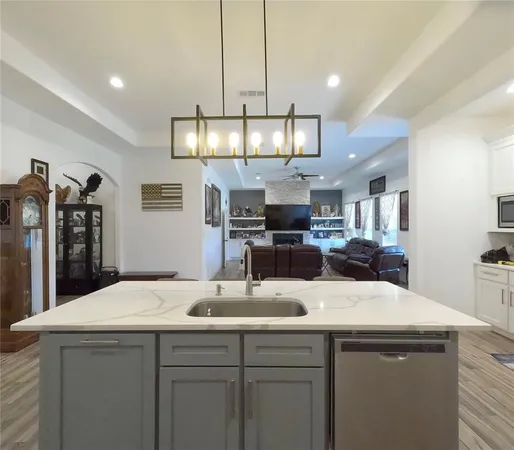 a kitchen with a sink a counter space appliances and cabinets