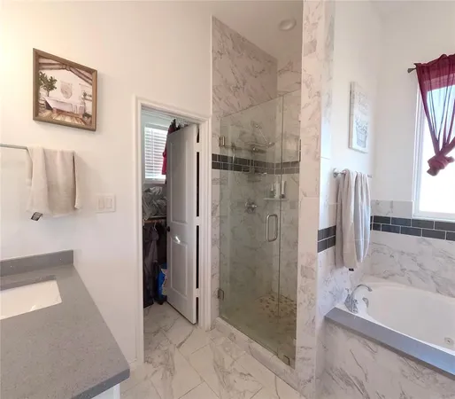 a bathroom with a granite countertop sink mirror and a bathtub