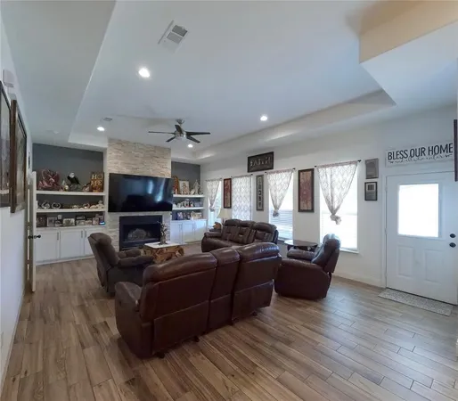a living room with furniture a flat screen tv and kitchen view