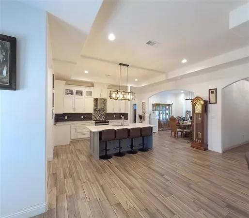 a large kitchen with a lot of counter space and a wooden floor