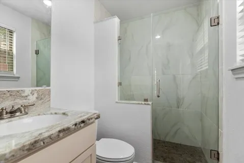 a bathroom with a granite countertop sink toilet and shower