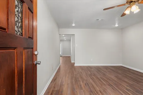 a view of a hallway with wooden floor