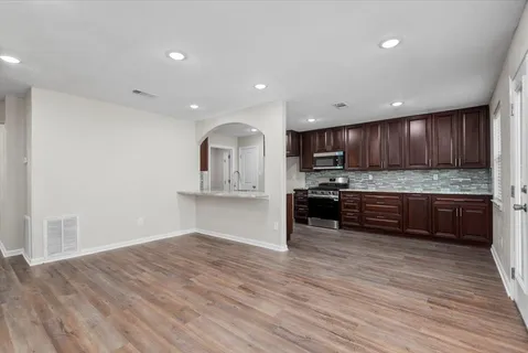 a kitchen with stainless steel appliances granite countertop a sink refrigerator and cabinets