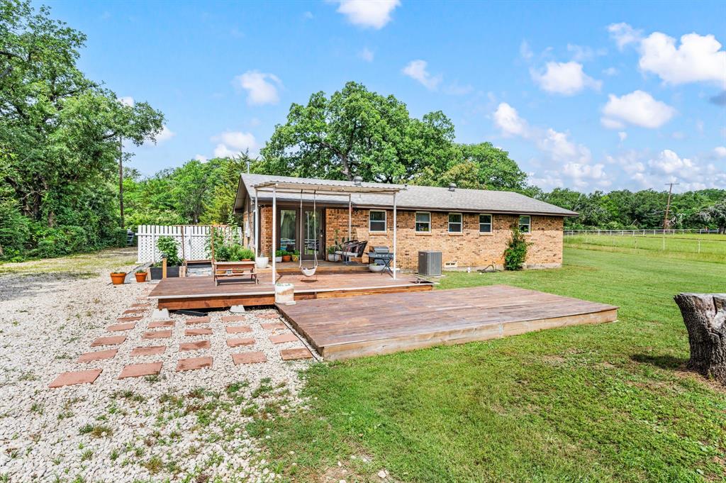 3900 Moseley Road Cross Roads, TX 76227 - Photo 22 of 36 Spacious backyard featuring a multi-level wood deck, a covered patio area, and a white picket fence