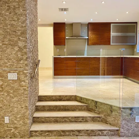 a living room with stainless steel appliances kitchen island granite countertop a stove and a refrigerator