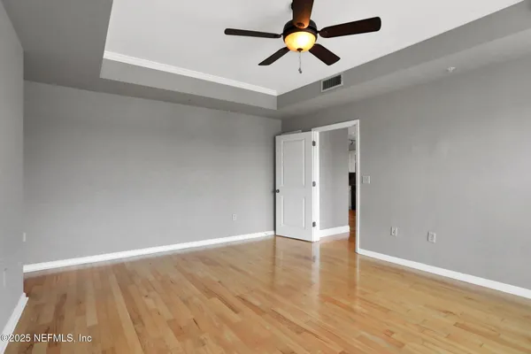 an empty room with window and a ceiling fan