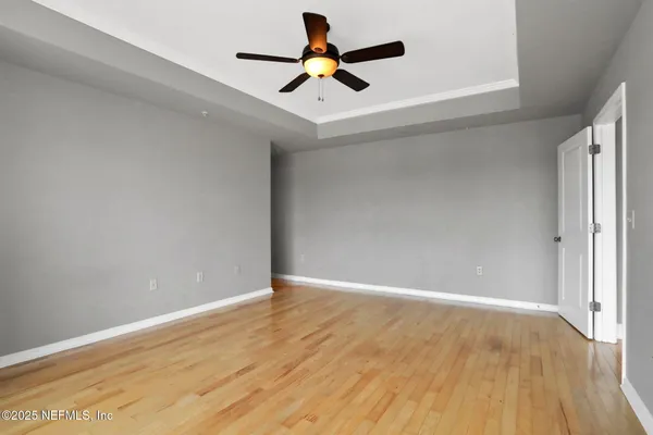 an empty room with a window and a fan