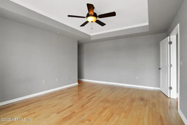 an empty room with a window and a fan
