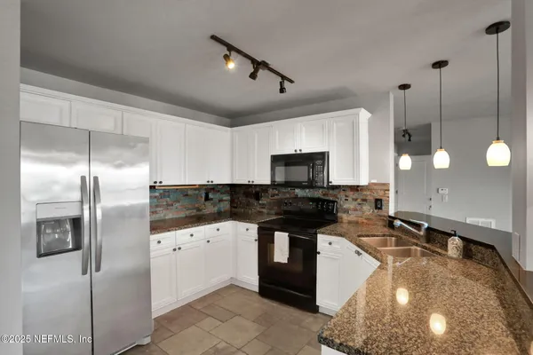 a kitchen with stainless steel appliances kitchen island a refrigerator a sink and a counter top space