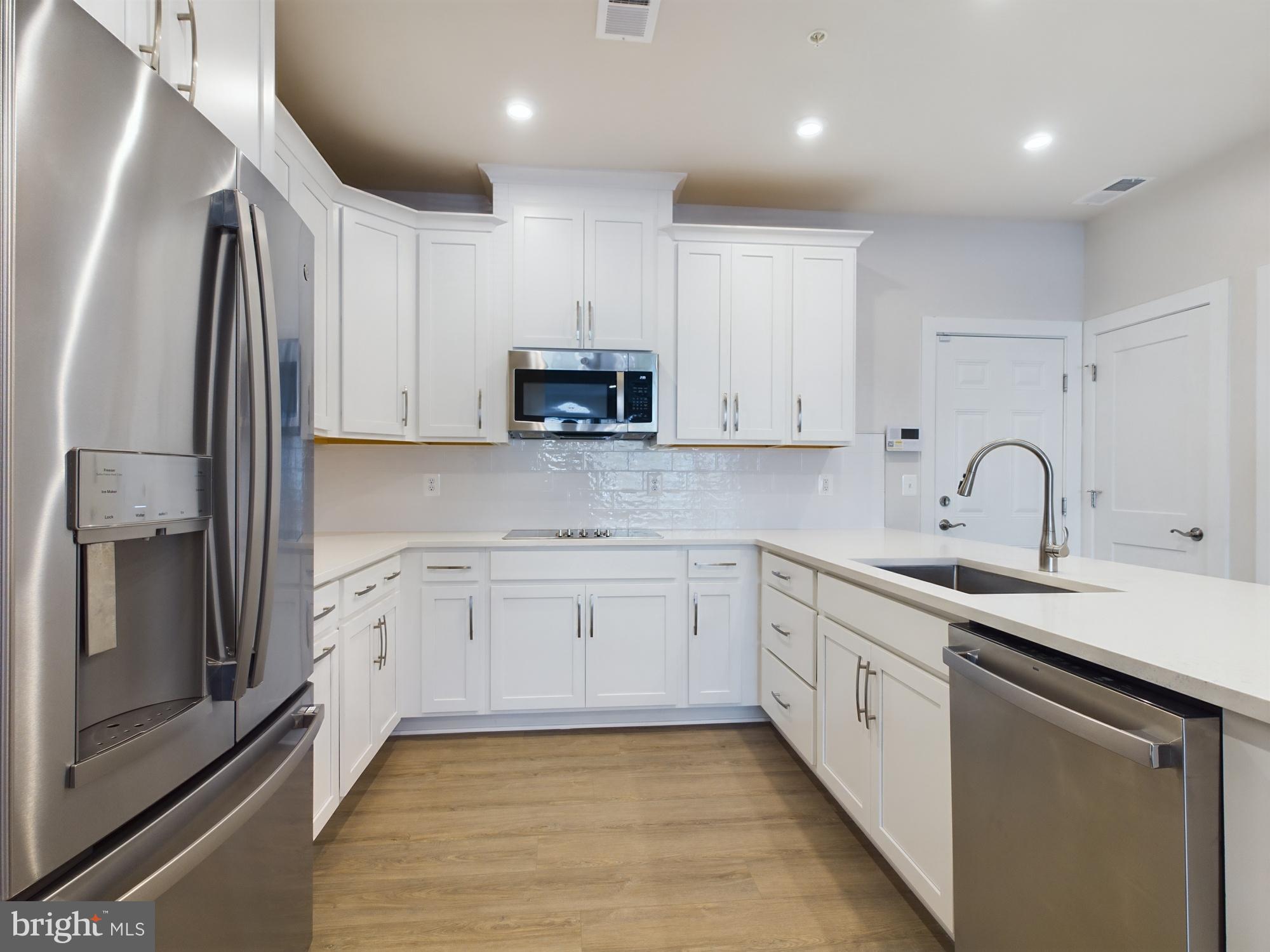 43801 Middleway Terrace Ashburn, VA 20147 - Photo 12 of 54 a kitchen with stainless steel appliances granite countertop a refrigerator sink and white cabinets