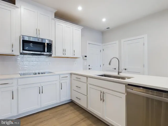 a kitchen with a sink and wooden floor