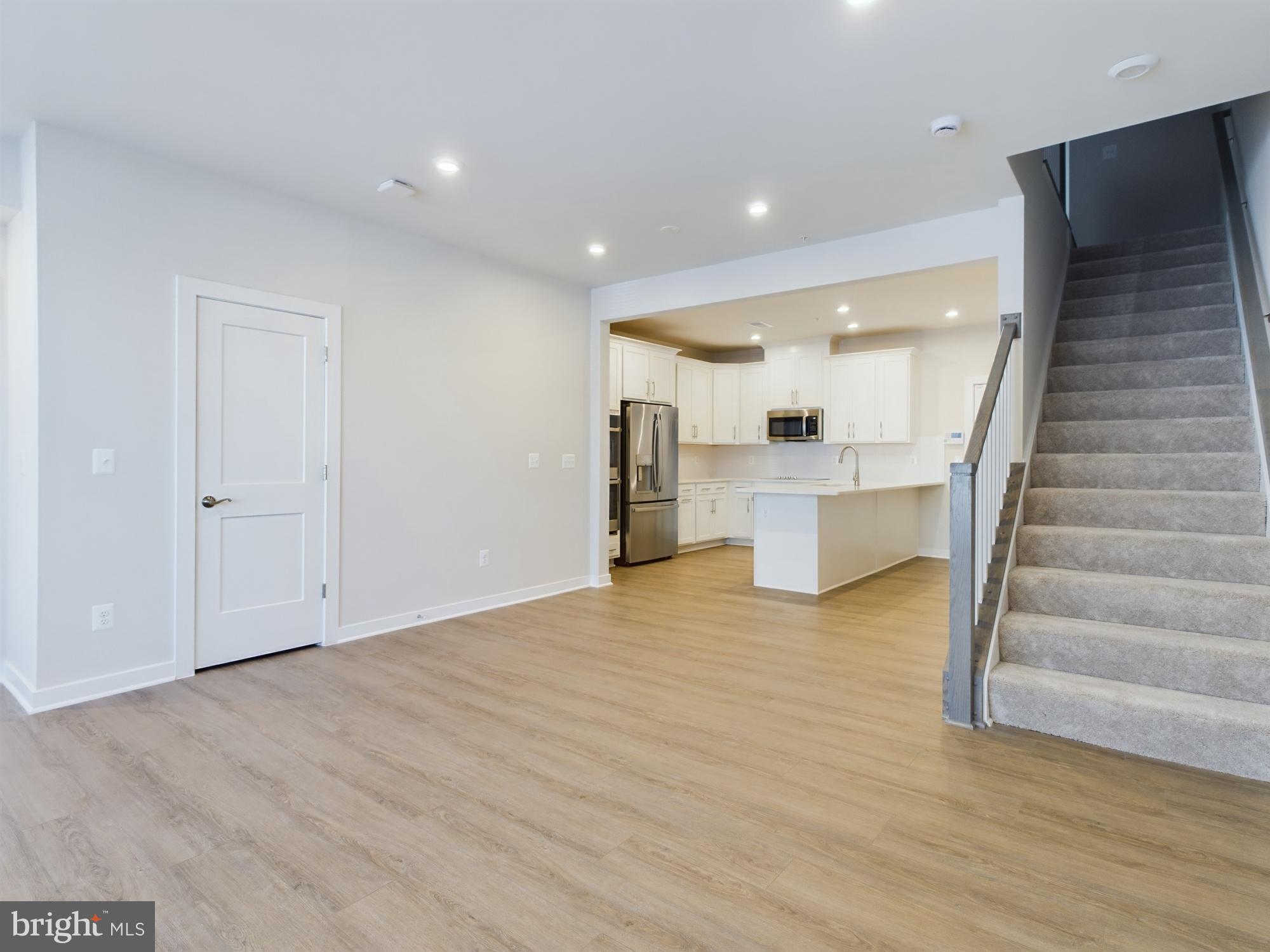 43801 Middleway Terrace Ashburn, VA 20147 - Photo 7 of 54 a view of an empty room with wooden floor and staircase