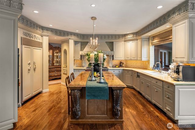 a kitchen with sink refrigerator dining table and chairs