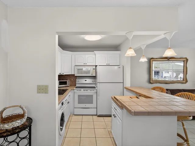 a kitchen with granite countertop a sink a counter space and stainless steel appliances