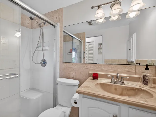 a bathroom with a sink toilet vanity and shower