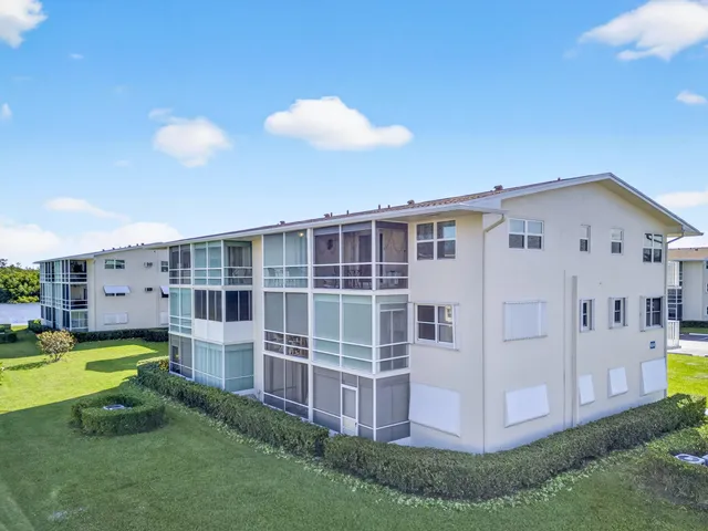 a view of a house with a big yard and large trees