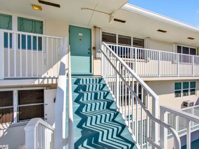 a view of entryway stairs and hall with wooden floor