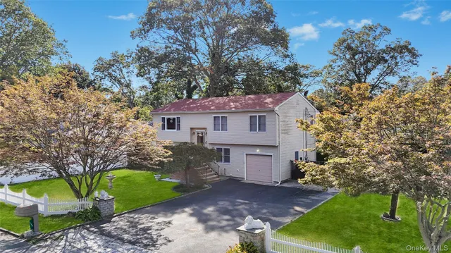 a front view of a house with a garden and tree