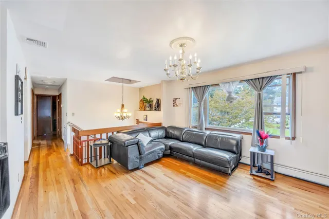 a living room with furniture a wooden floor and a chandelier