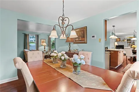 a view of a dining room with furniture a chandelier and wooden floor