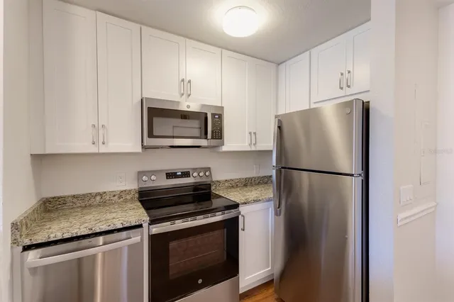 a kitchen with refrigerator a microwave and cabinets