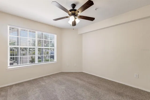 an empty room with window and ceiling fan