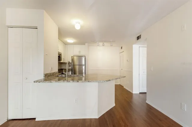 a large white kitchen with wooden floor