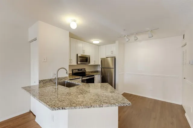 a kitchen with stainless steel appliances granite countertop a sink a refrigerator and a granite counter tops