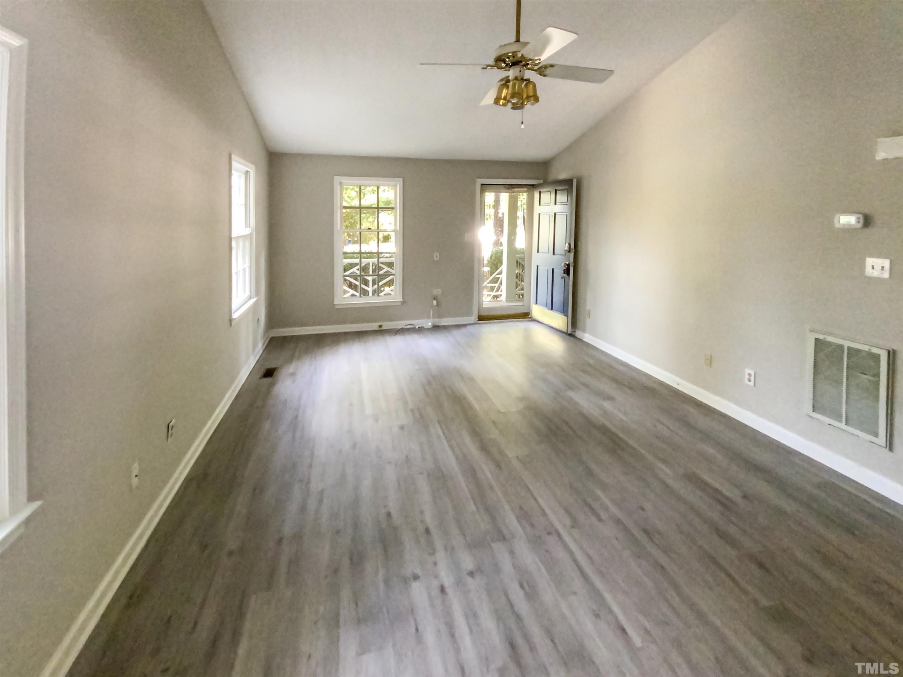 11817 North Exeter Way Raleigh, NC 27613 - Photo 16 of 17 an empty room with wooden floor and windows