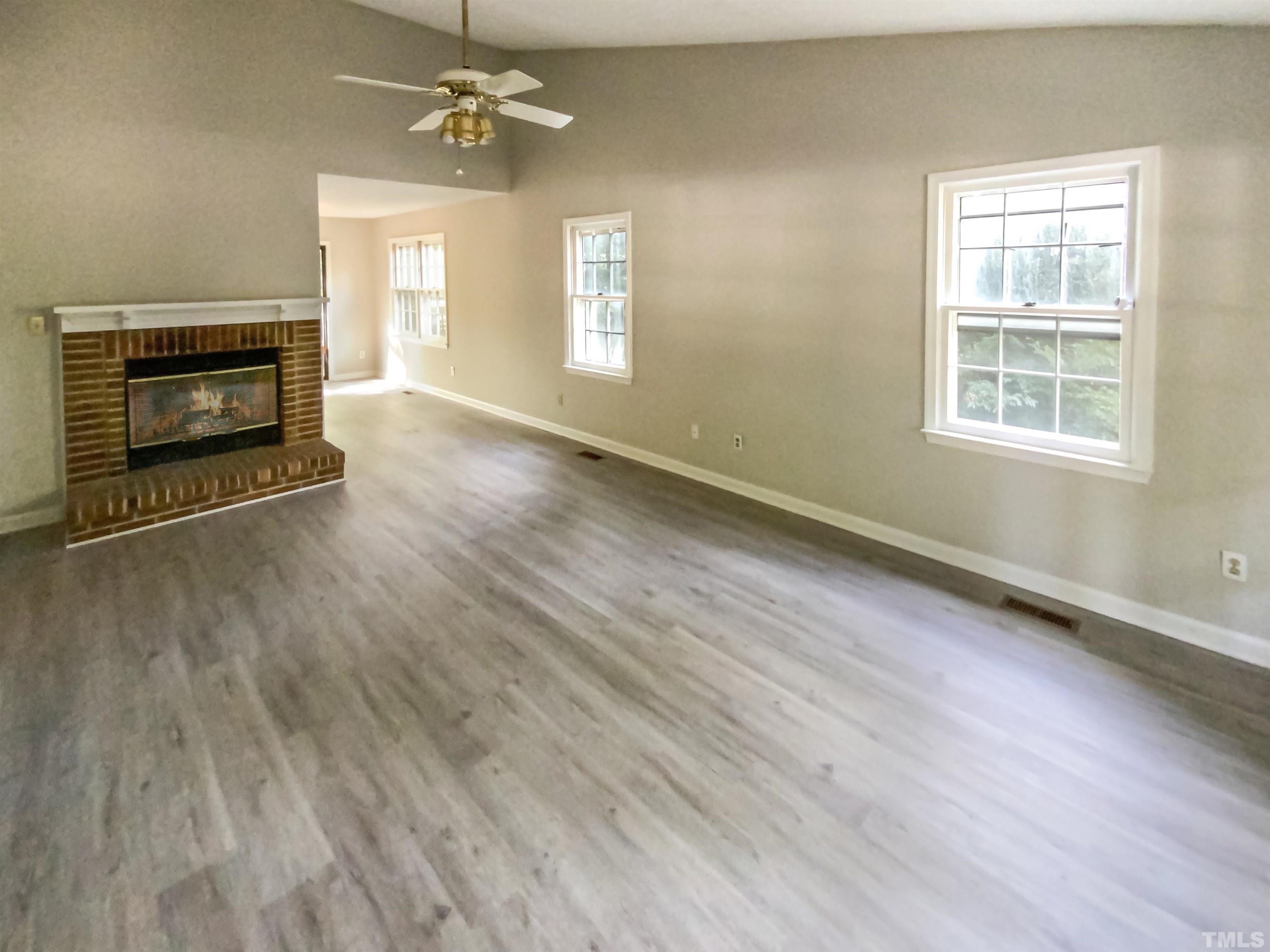 11817 North Exeter Way Raleigh, NC 27613 - Photo 5 of 17 an empty room with chandelier fan and windows