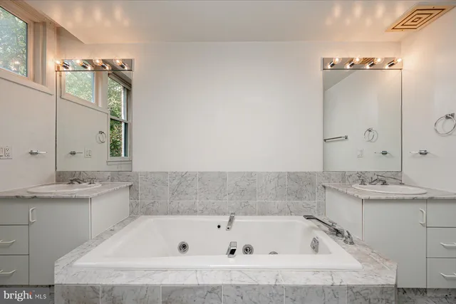 a bathroom with a tub sink and mirror