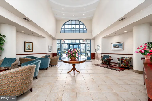 a living room with furniture a dining table and a chandelier