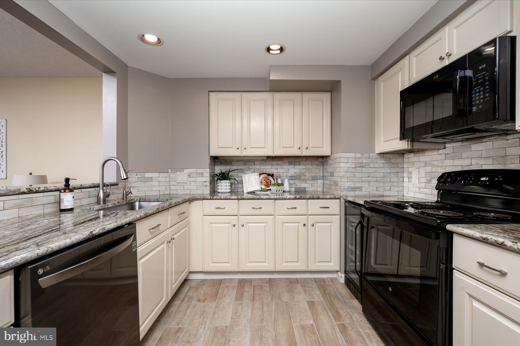 930 Astern Way, Unit 405 Annapolis, MD 21401 - Photo 5 of 27 a kitchen with stainless steel appliances granite countertop a sink dishwasher stove and microwave with wooden cabinets