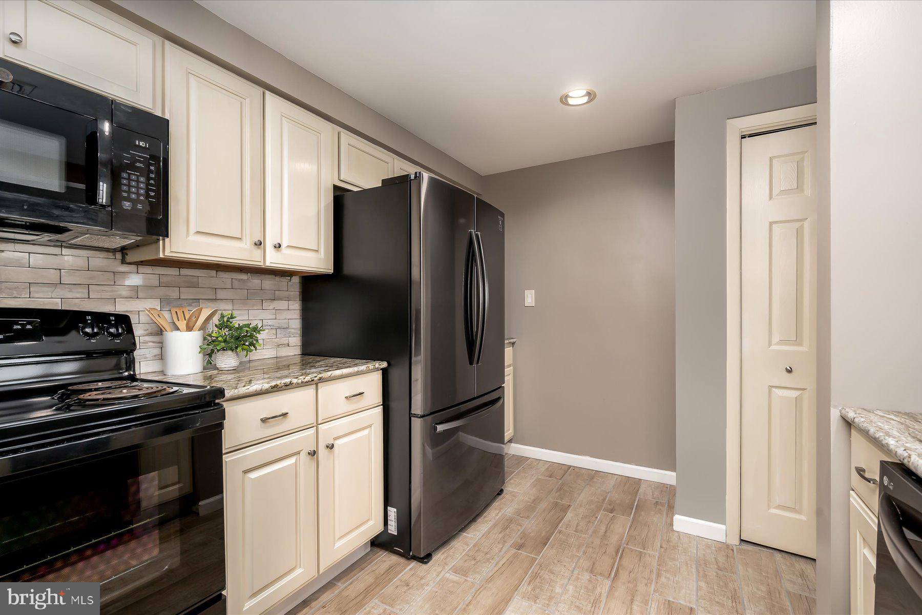 930 Astern Way, Unit 405 Annapolis, MD 21401 - Photo 6 of 27 a kitchen with granite countertop a refrigerator stove and microwave