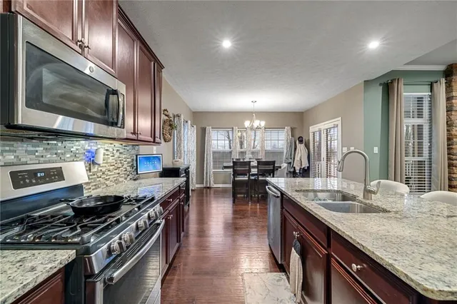 a kitchen with stainless steel appliances granite countertop a stove a sink dishwasher a microwave oven with granite countertops and cabinets