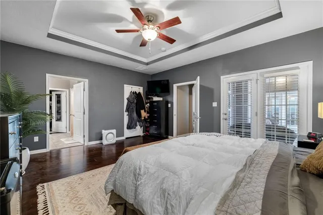 a large bedroom with wooden floor and large window