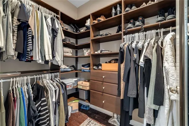a view of walk in closet with clothes and shoes