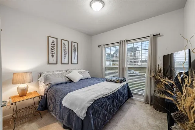 a bedroom with a bed and a flat tv screen on dresser