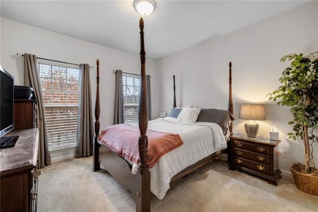 a bed room with a bed tv and a window