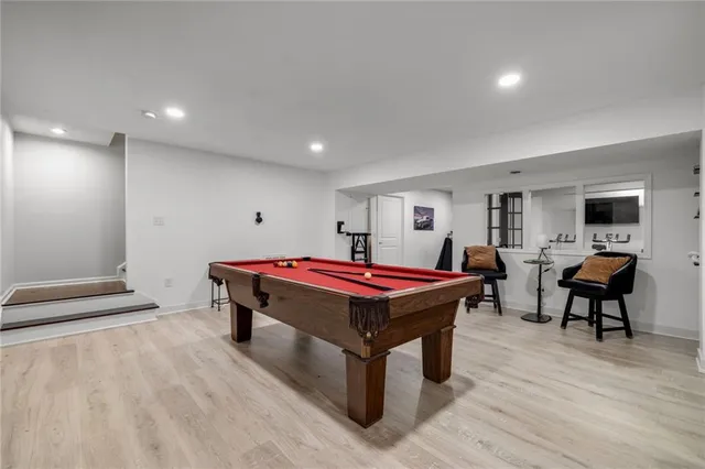 a room with pool table and windows