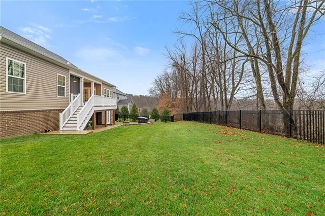 a view of a yard in front of a house with large trees