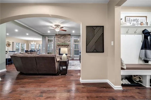 a living room with furniture a wooden floor and a kitchen view