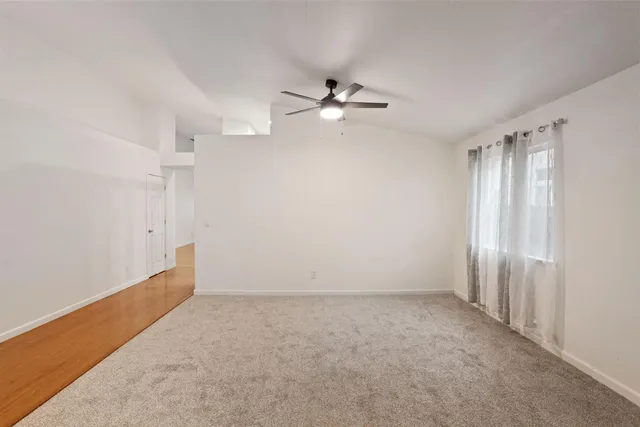 an empty room with a ceiling fan and a window