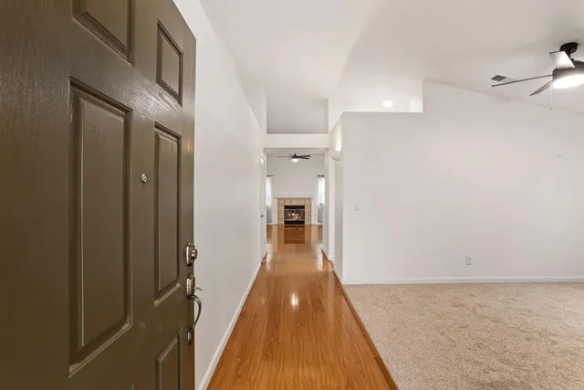 a view of a hallway with wooden floor and staircase