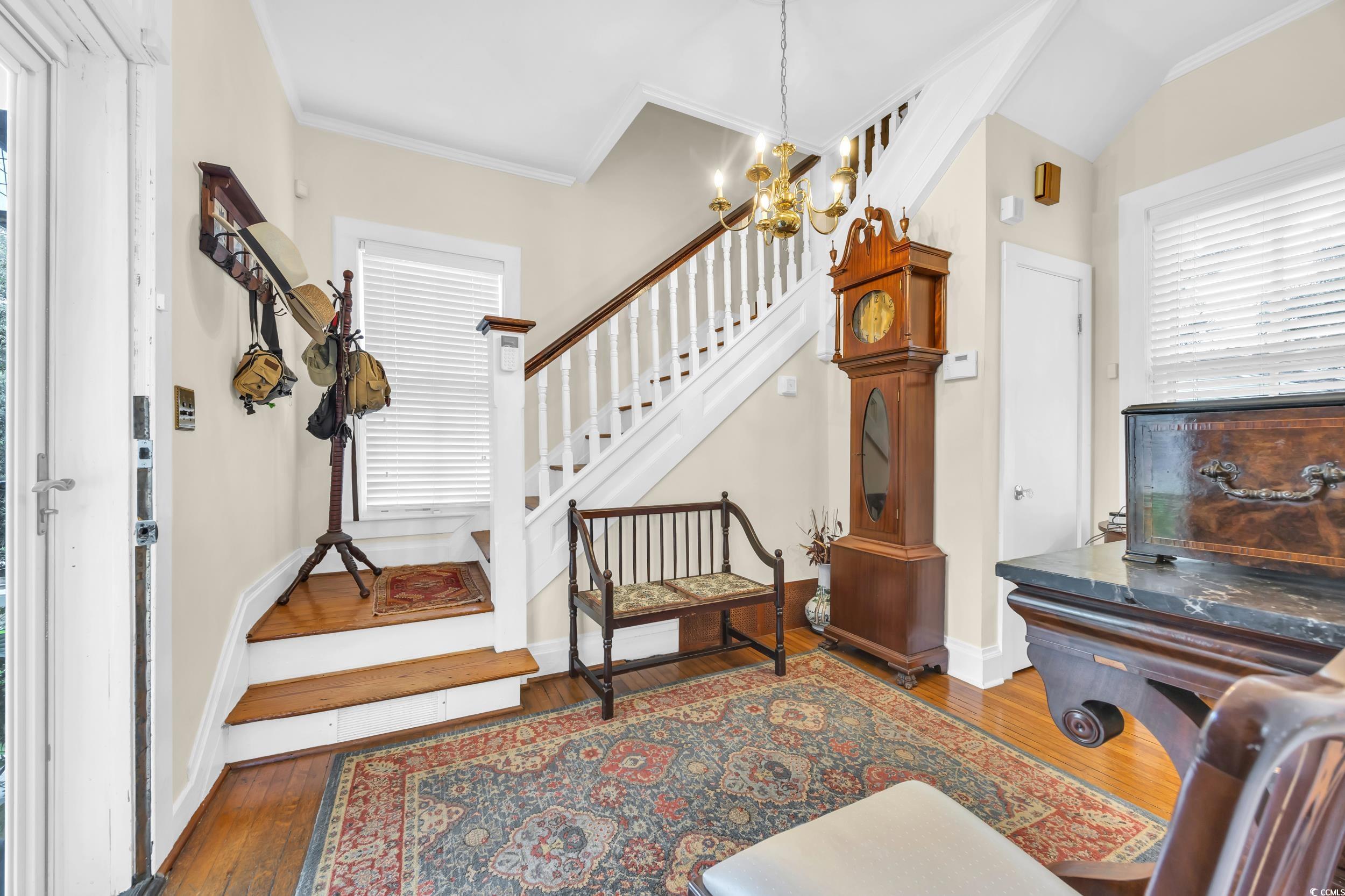 209 Cannon Street Georgetown, SC 29440 - Photo 18 of 34 Foyer entrance with crown molding, hardwood / wood-style flooring, a chandelier, and stairs