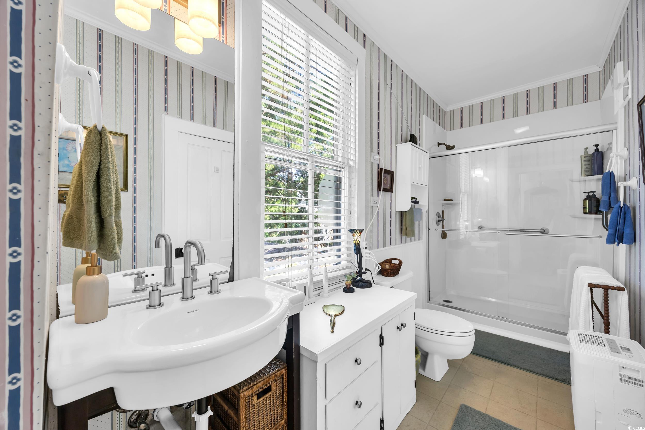 209 Cannon Street Georgetown, SC 29440 - Photo 25 of 34 Full bath with wallpapered walls, a stall shower, and a chandelier