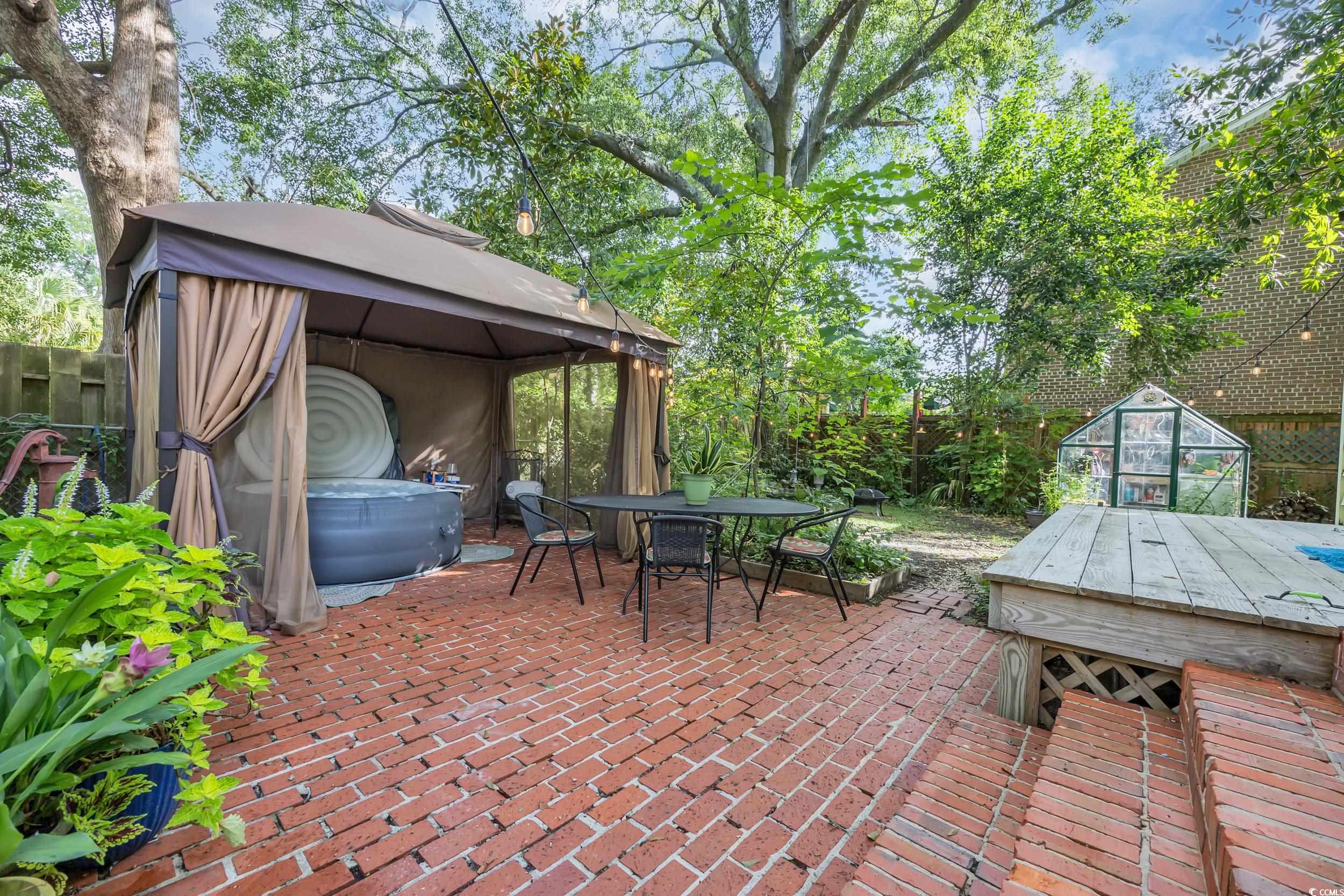209 Cannon Street Georgetown, SC 29440 - Photo 28 of 34 Fenced backyard with a gazebo, a greenhouse, a patio area, an outdoor structure, and outdoor dining area