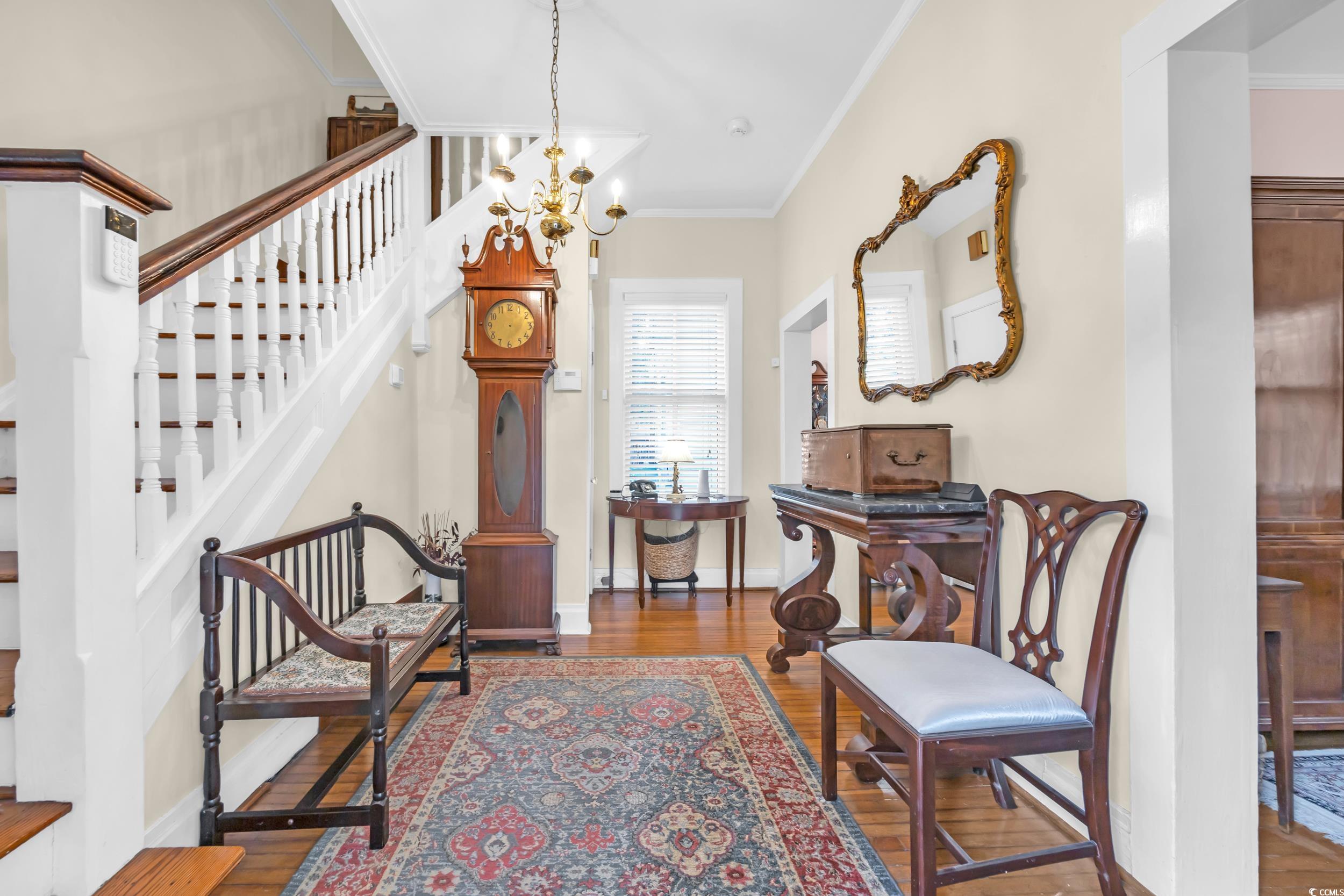 209 Cannon Street Georgetown, SC 29440 - Photo 8 of 34 Sitting room featuring crown molding, a chandelier, wood finished floors, and stairs