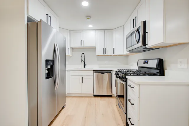 a kitchen with stainless steel appliances granite countertop a refrigerator sink and stove