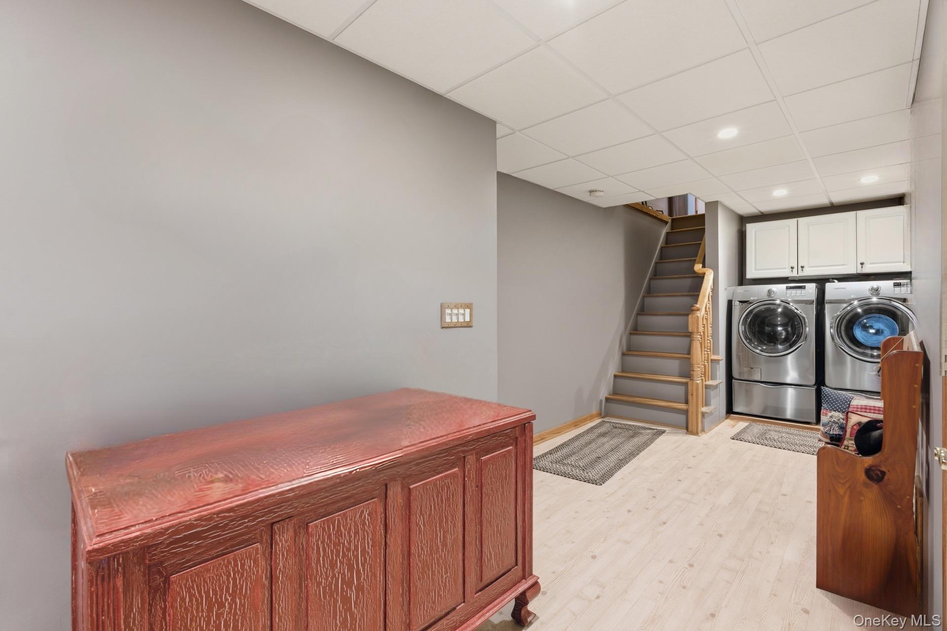 347 Wading River Road Manorville, NY 11949 - Photo 15 of 30 Laundry room with a drop ceiling, light wood-style flooring, recessed lighting, washer and dryer, and cabinet space